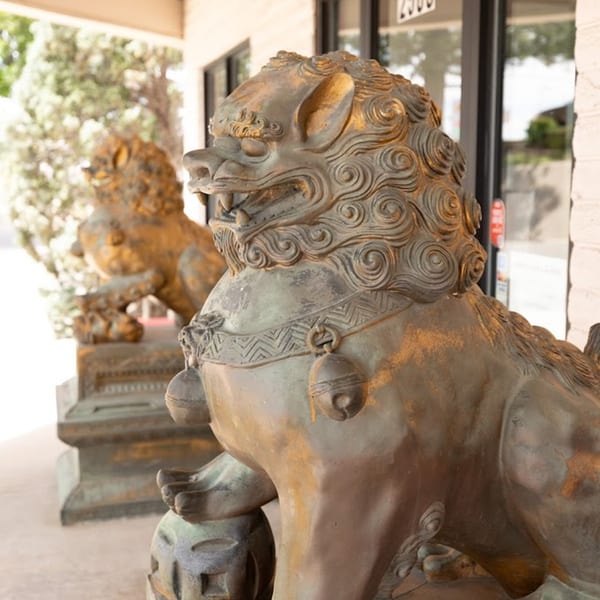 Two bronze Foo Dog statues with gold accents guard the entrance of Shanghai Garden restaurant.